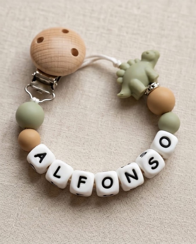 Chupetero con el nombre ALFONSO, bolitas verde salvia y beige y charm de dinosaurio